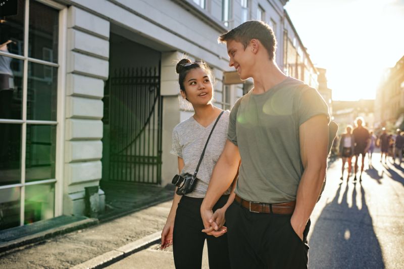 couple holding hands while walking down the street