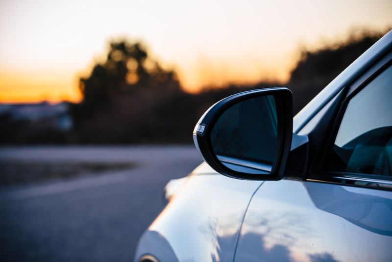 closeup of a car side mirror at sunset