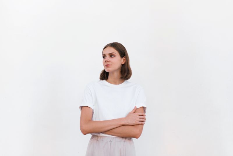 serious woman with arms crossed looking off into distance