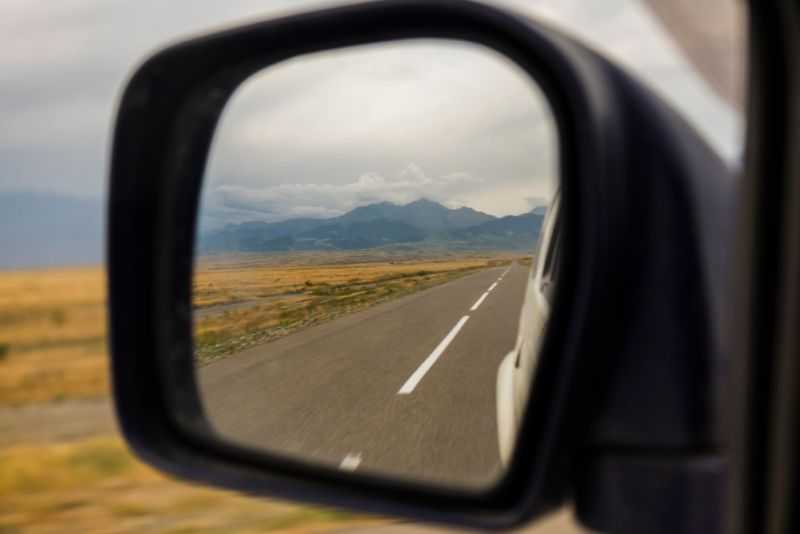 View of the mountains in the side mirror of a car