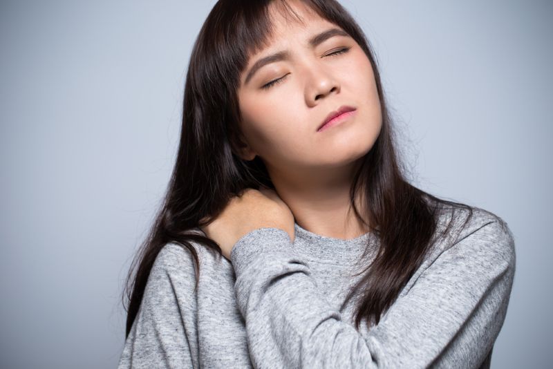 Woman grabbing her shoulder in serious pain