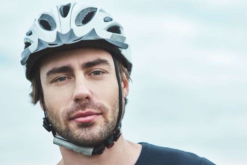 man outside in the cloudy weather wearing a bike helmet