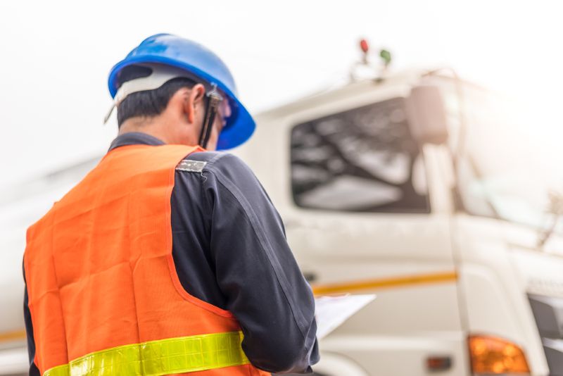 Semi truck driver standing outside of his truck