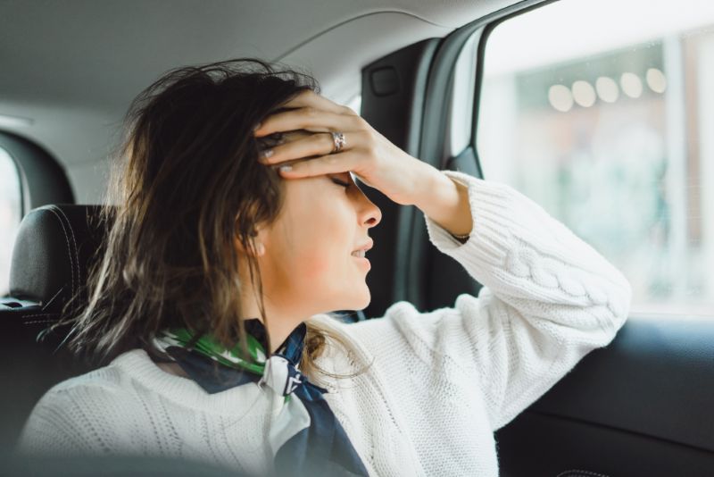 Woman stressed out riding in the back seat of car
