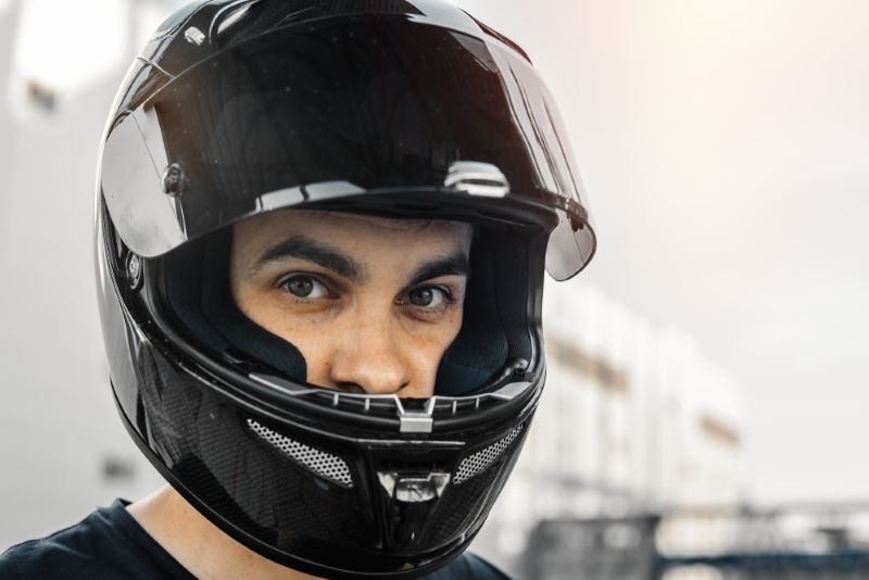 A man wearing a black motorcycle helmet