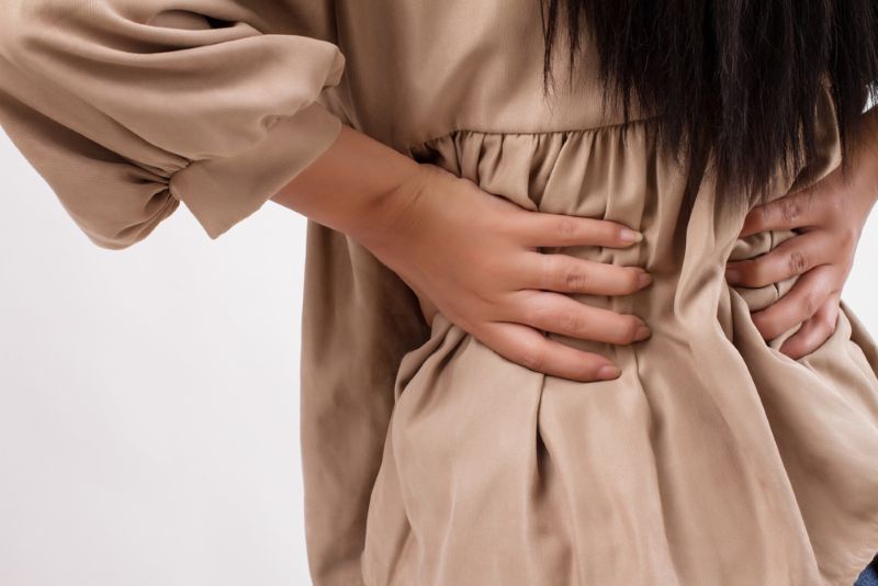 A woman grabbing her lower back in pain
