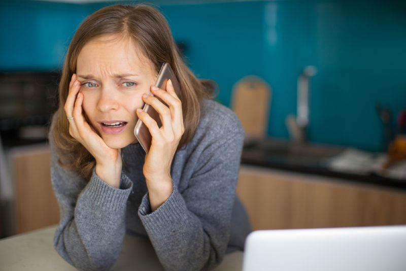 Stressed and concerned woman on phone call at home