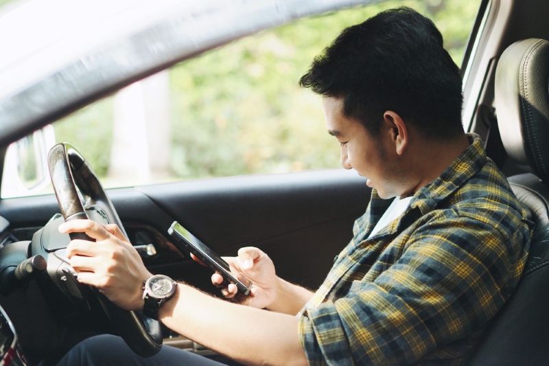 Man using his cell phone in the car