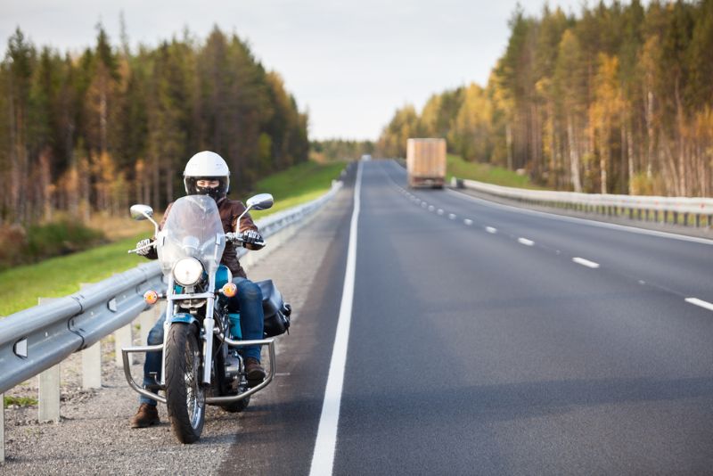 Woman on motorcycle pulled off on side of the highway